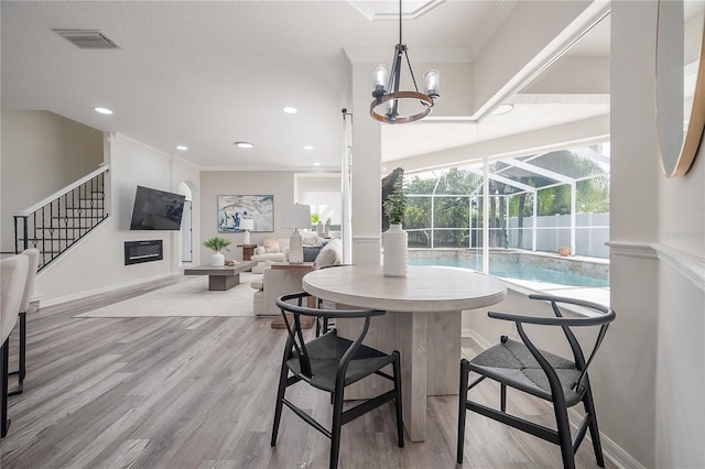 dining area with crown molding and light wood-type flooring