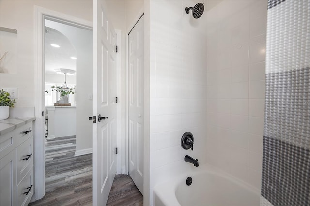 bathroom with vanity, wood-type flooring, and tiled shower / bath