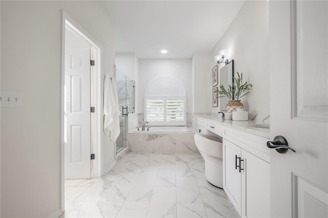 bathroom featuring vanity and independent shower and bath