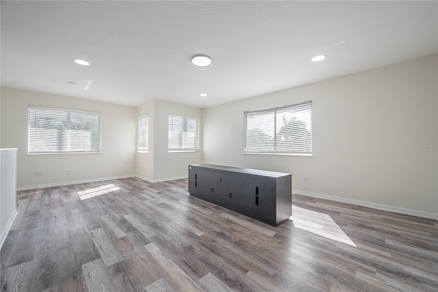 spare room with hardwood / wood-style floors and plenty of natural light