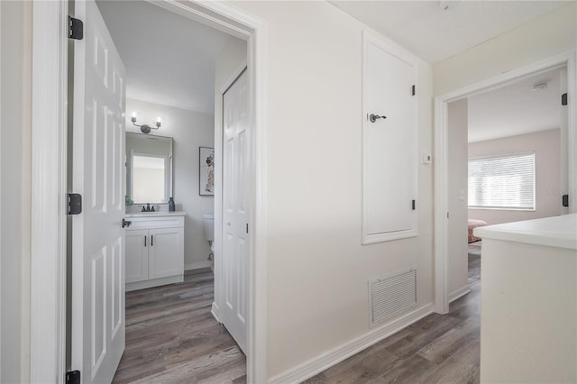 hallway featuring light hardwood / wood-style floors and sink