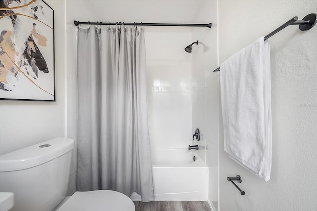 bathroom featuring toilet, shower / tub combo with curtain, and wood-type flooring