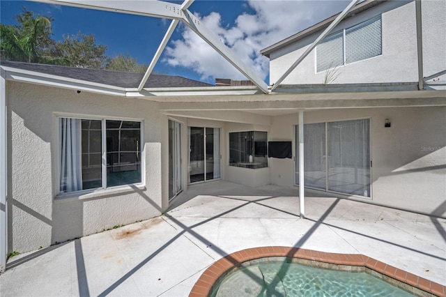 rear view of property featuring a patio and a lanai