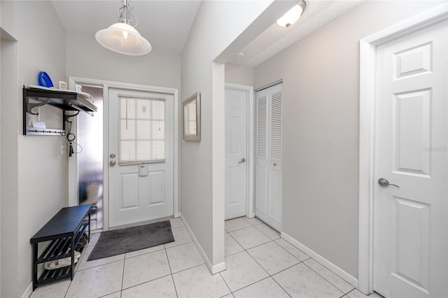 entryway featuring a textured ceiling and light tile patterned flooring