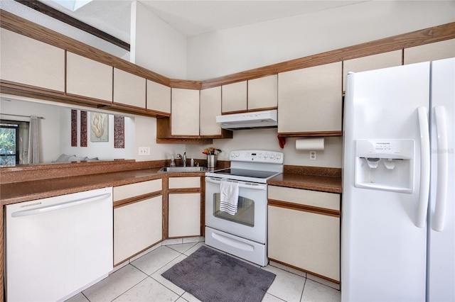 kitchen featuring white appliances, light tile patterned flooring, white cabinetry, and sink