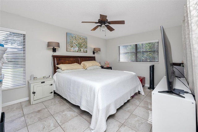 tiled bedroom with a textured ceiling and ceiling fan