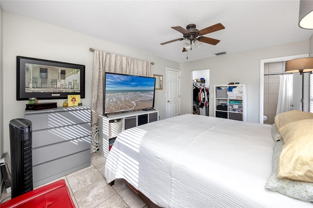 tiled bedroom featuring a closet, a textured ceiling, and ceiling fan