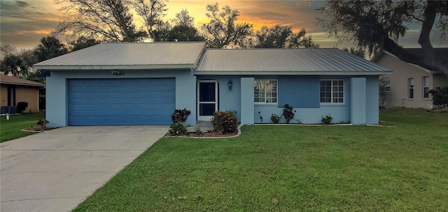 ranch-style home with a yard and a garage