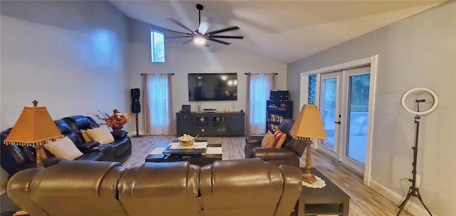 living room with ceiling fan, lofted ceiling, and light wood-type flooring