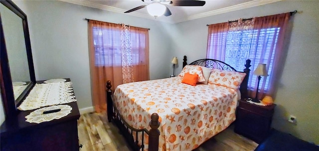 bedroom with ornamental molding, hardwood / wood-style flooring, multiple windows, and ceiling fan