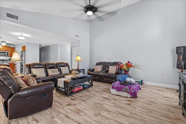 1467 Monte St, Port Charlotte, FL 33952 - living area with light wood-style floors, ceiling fan, a high ceiling, and baseboards