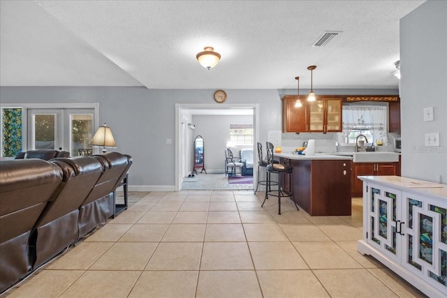 1467 Monte St, Port Charlotte, FL 33952 - kitchen with a sink, open floor plan, light countertops, a kitchen breakfast bar, and glass insert cabinets