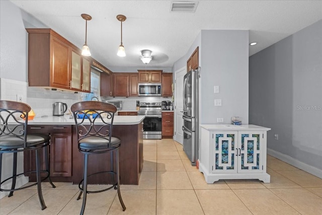 1467 Monte St, Port Charlotte, FL 33952 - kitchen with appliances with stainless steel finishes, a peninsula, light countertops, and backsplash