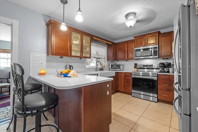 1467 Monte St, Port Charlotte, FL 33952 - kitchen with stainless steel appliances, a peninsula, tasteful backsplash, light countertops, and a textured ceiling