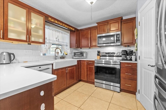 1467 Monte St, Port Charlotte, FL 33952 - kitchen with stainless steel appliances, tasteful backsplash, light countertops, light tile patterned floors, and a textured ceiling