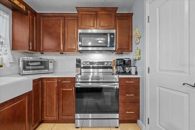 1467 Monte St, Port Charlotte, FL 33952 - kitchen featuring appliances with stainless steel finishes, backsplash, light countertops, a textured ceiling, and light tile patterned flooring