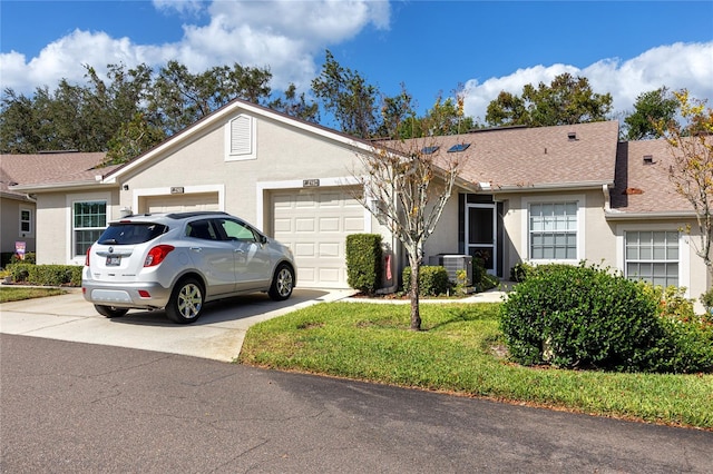 ranch-style home with a garage, central air condition unit, and a front lawn