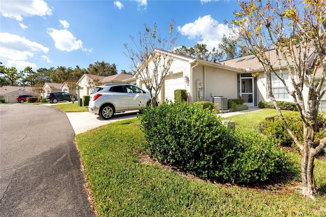 view of side of property featuring central AC, a lawn, and a garage