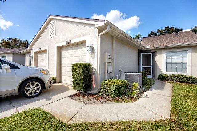 view of side of property featuring a garage and central AC unit