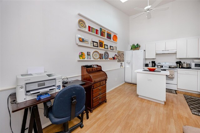 4234 Chesterfield Cir, Palm Harbor, FL 34683 - kitchen with white appliances, under cabinet range hood, a kitchen island, a towering ceiling, and a desk