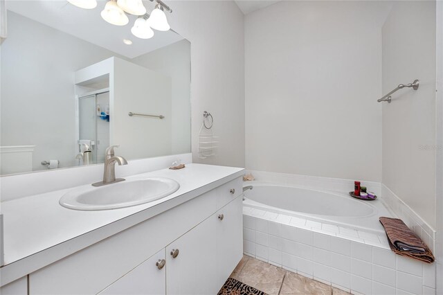 4234 Chesterfield Cir, Palm Harbor, FL 34683 - bathroom with vanity, a garden tub, a chandelier, a stall shower, and tile patterned floors