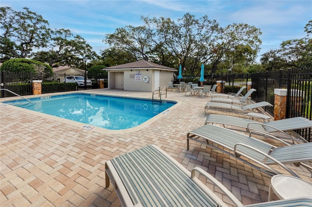 view of swimming pool featuring an outdoor structure and a patio area