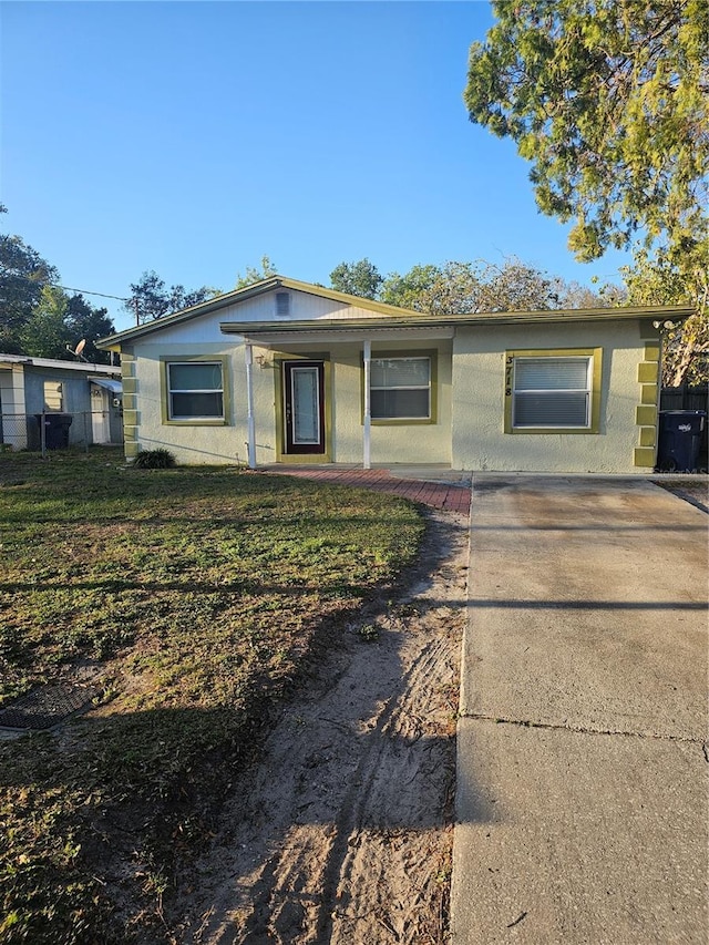 single story home featuring stucco siding and a front yard