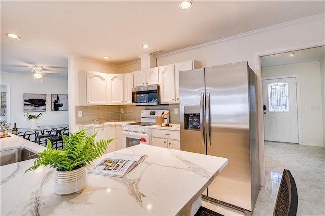 kitchen featuring ceiling fan, appliances with stainless steel finishes, white cabinetry, light stone countertops, and crown molding