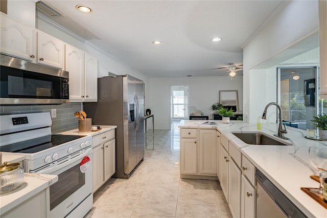 kitchen featuring tasteful backsplash, ceiling fan, appliances with stainless steel finishes, crown molding, and sink