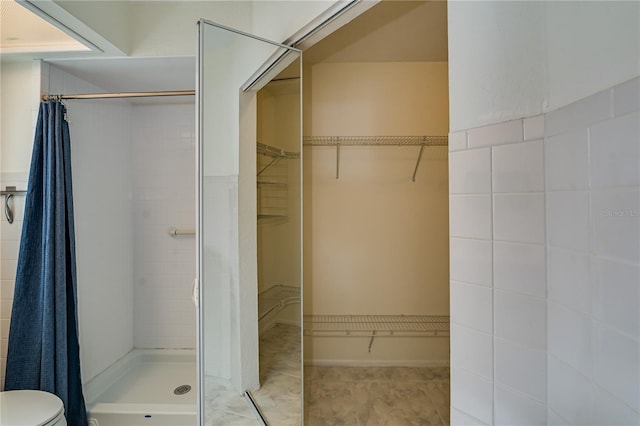 bathroom featuring a shower with curtain, toilet, and tile patterned flooring