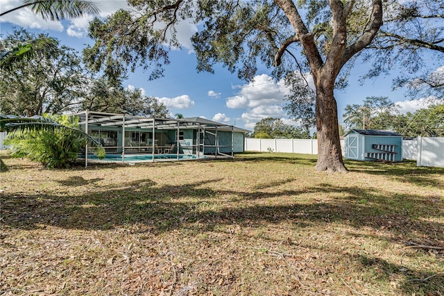 view of yard featuring a fenced in pool, a storage unit, and a lanai