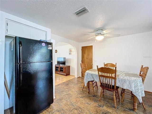 dining room with ceiling fan, hardwood / wood-style flooring, and a textured ceiling