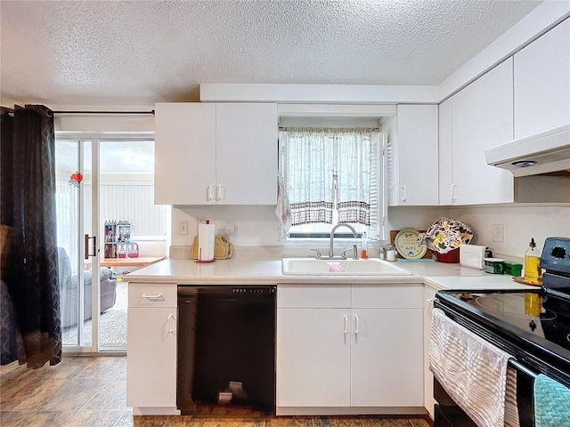 kitchen with white cabinetry, a healthy amount of sunlight, black appliances, and sink