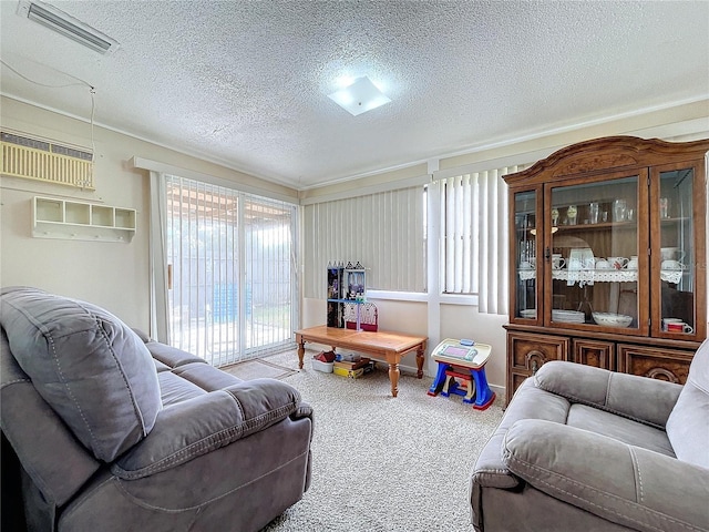 living room featuring an AC wall unit, a textured ceiling, and carpet floors