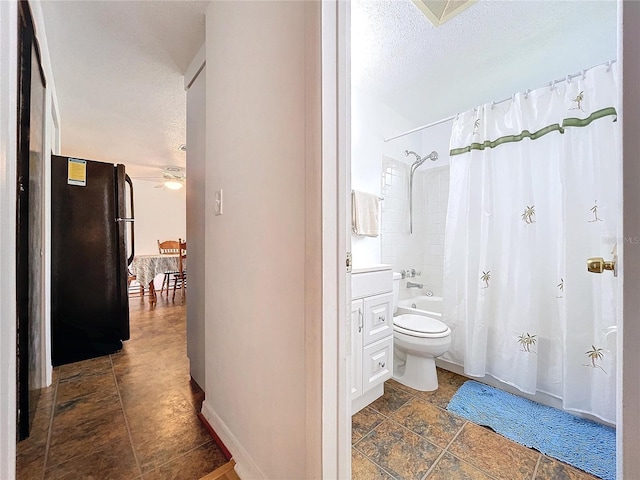 full bathroom with a textured ceiling, toilet, ceiling fan, shower / bath combo with shower curtain, and vanity