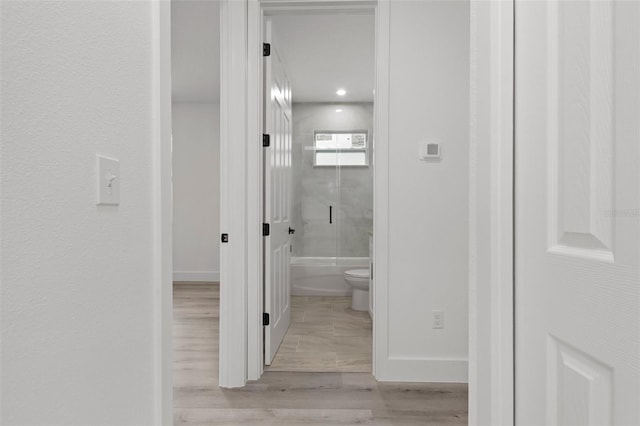 bathroom featuring bath / shower combo with glass door, wood-type flooring, and toilet