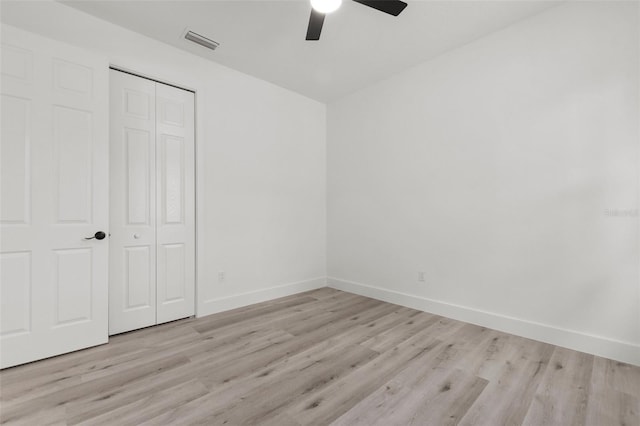 unfurnished bedroom featuring a closet, light wood-type flooring, and ceiling fan