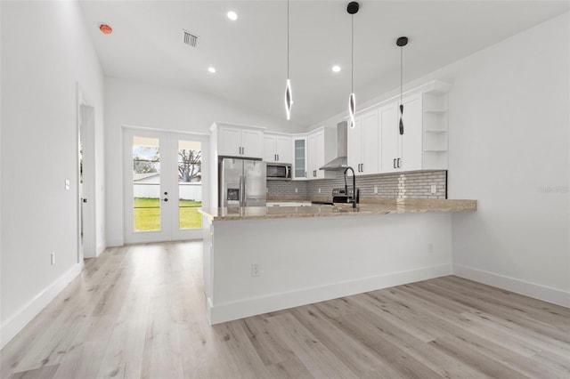 kitchen with stainless steel appliances, kitchen peninsula, hanging light fixtures, white cabinets, and french doors