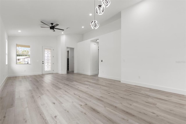 unfurnished living room featuring light hardwood / wood-style flooring, lofted ceiling, and ceiling fan