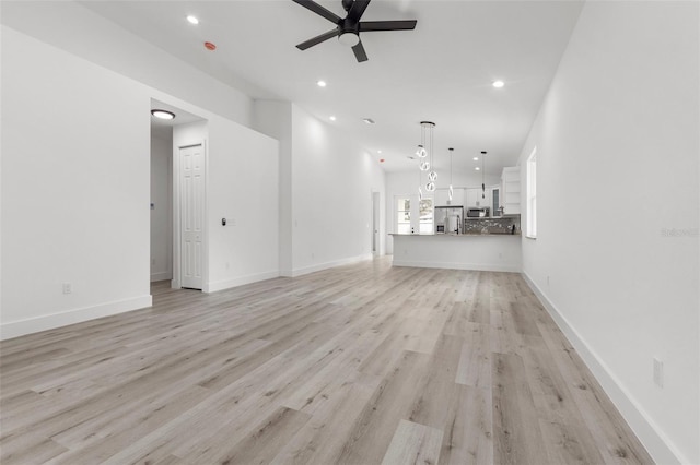 unfurnished living room with ceiling fan and light hardwood / wood-style flooring