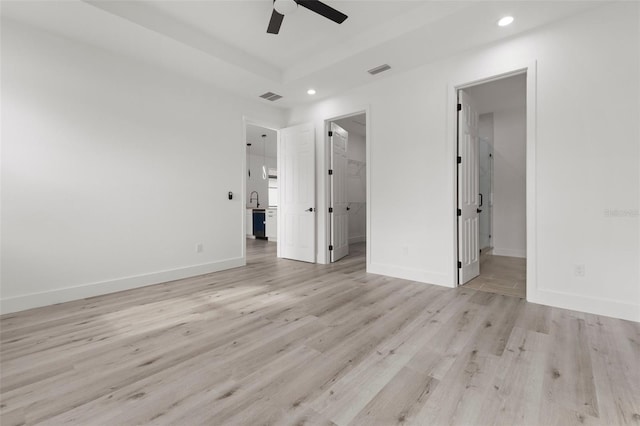 unfurnished bedroom featuring ensuite bathroom, ceiling fan, a spacious closet, a closet, and light wood-type flooring