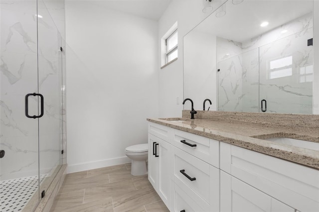 bathroom with toilet, vanity, and a shower with shower door