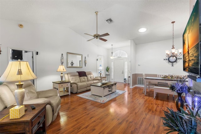 living room featuring hardwood / wood-style flooring, high vaulted ceiling, and ceiling fan with notable chandelier