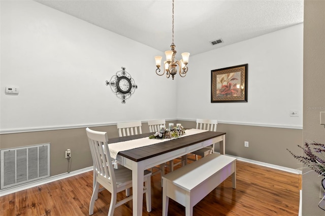 dining area with a chandelier and wood-type flooring