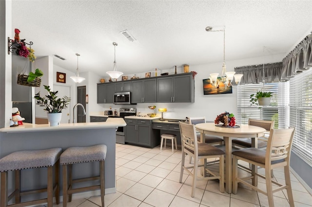 kitchen with stainless steel appliances, sink, pendant lighting, gray cabinets, and a textured ceiling