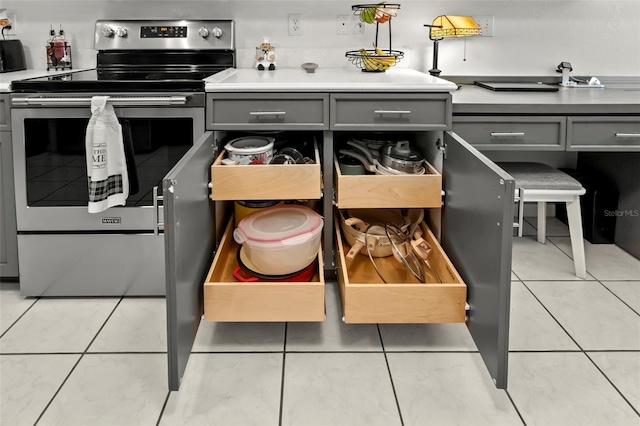 kitchen with stainless steel electric range, gray cabinetry, and light tile patterned floors