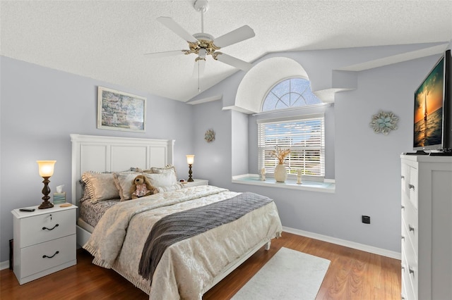 bedroom with ceiling fan, a textured ceiling, wood-type flooring, and lofted ceiling