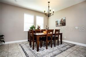 dining room featuring tile patterned flooring and a notable chandelier