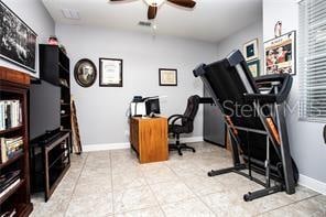 workout room featuring ceiling fan and light tile patterned flooring