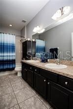 bathroom with tile patterned floors, vanity, toilet, and a shower with shower curtain